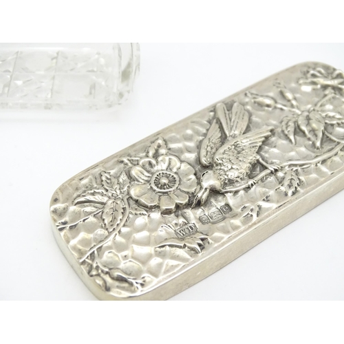 292 - A cut glass dressing table box the silver lid with embossed flower and bird detail, hallmarked Birmi... 