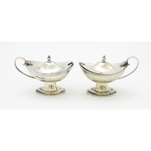 298 - A pair of silver mustard pots with blue glass liners hallmarked Birmingham 1918, maker J. Sherwood &... 