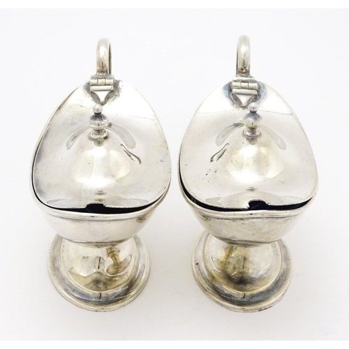 298 - A pair of silver mustard pots with blue glass liners hallmarked Birmingham 1918, maker J. Sherwood &... 