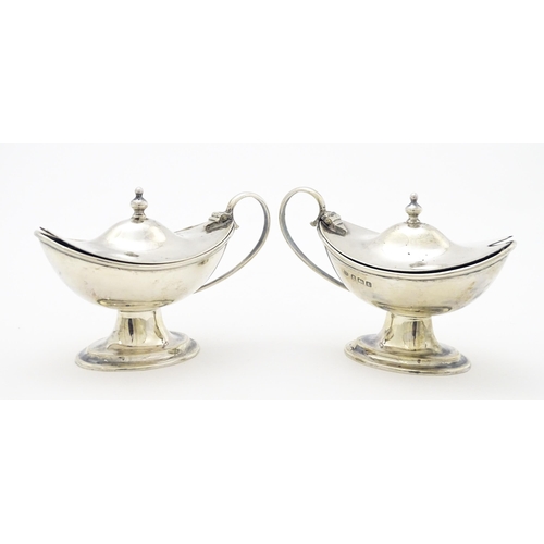 298 - A pair of silver mustard pots with blue glass liners hallmarked Birmingham 1918, maker J. Sherwood &... 