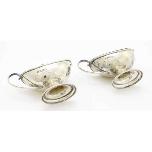 298 - A pair of silver mustard pots with blue glass liners hallmarked Birmingham 1918, maker J. Sherwood &... 