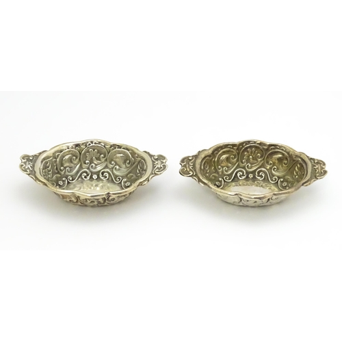 299 - A pair of Victorian silver salts with embossed decoration, hallmarked Chester 1899, maker William Ai... 