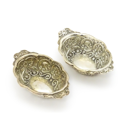 299 - A pair of Victorian silver salts with embossed decoration, hallmarked Chester 1899, maker William Ai... 