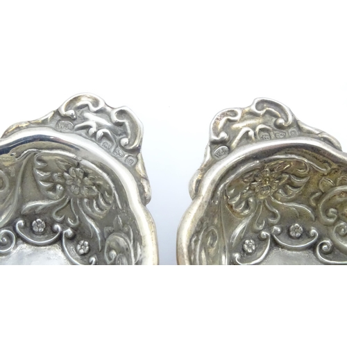 299 - A pair of Victorian silver salts with embossed decoration, hallmarked Chester 1899, maker William Ai... 