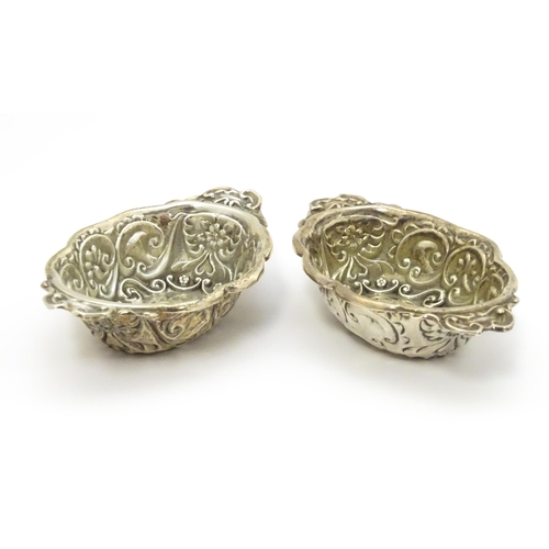 299 - A pair of Victorian silver salts with embossed decoration, hallmarked Chester 1899, maker William Ai... 