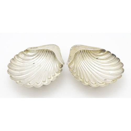 301 - A pair of silver butter dishes of scallop shell form, hallmarked Sheffield 1909, maker Atkin Brother... 