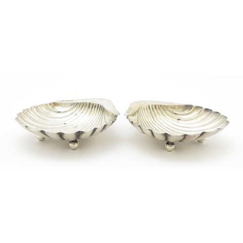 301 - A pair of silver butter dishes of scallop shell form, hallmarked Sheffield 1909, maker Atkin Brother... 