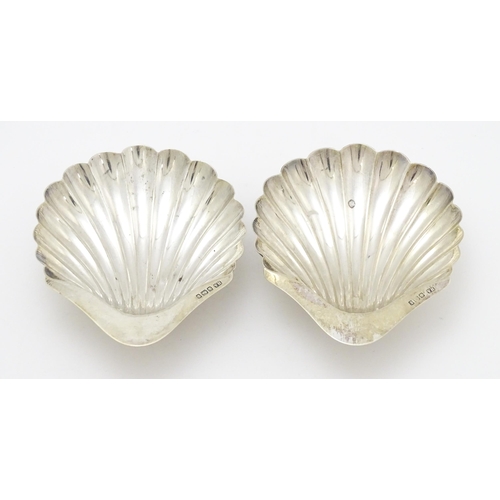 301 - A pair of silver butter dishes of scallop shell form, hallmarked Sheffield 1909, maker Atkin Brother... 