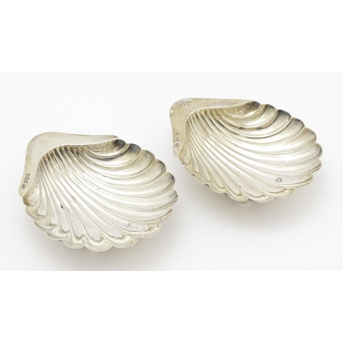 301 - A pair of silver butter dishes of scallop shell form, hallmarked Sheffield 1909, maker Atkin Brother... 