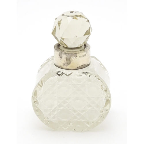 303 - A cut glass scent / perfume bottle with silver collar hallmarked Birmingham 1912, maker C. C. May & ... 