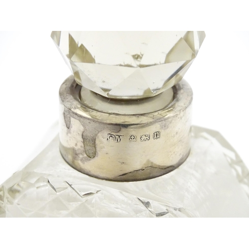 303 - A cut glass scent / perfume bottle with silver collar hallmarked Birmingham 1912, maker C. C. May & ... 