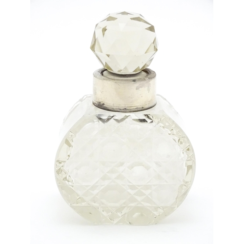 303 - A cut glass scent / perfume bottle with silver collar hallmarked Birmingham 1912, maker C. C. May & ... 