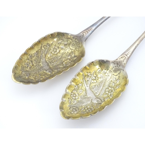 359 - A pair of William IV Irish silver berry spoons, the gilded bowls with embossed flower and bird detai... 