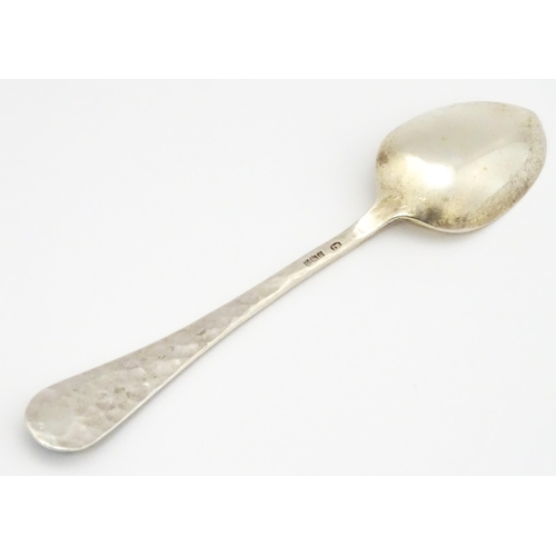 379 - A silver teaspoon with hammered decoration and cabochon detail to handle hallmarked Birmingham 1928,... 