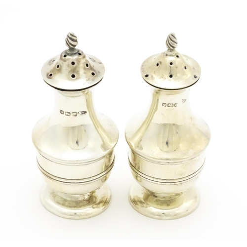 398 - A matched pair of silver pepperettes hallmarked Sheffield 1904 / 1906, maker Walker & Hall. Approx. ... 