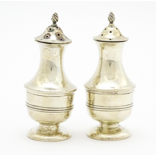 398 - A matched pair of silver pepperettes hallmarked Sheffield 1904 / 1906, maker Walker & Hall. Approx. ... 