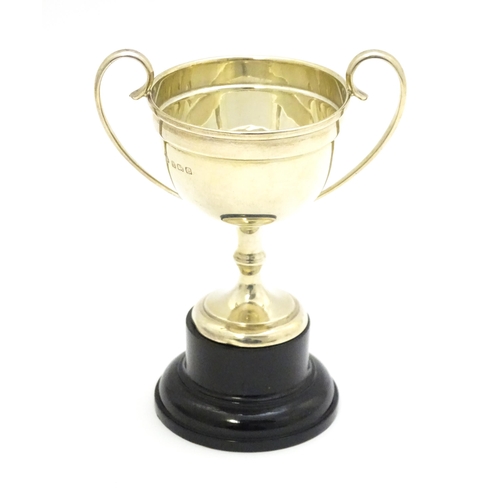 416 - A silver twin handled trophy cup, hallmarked Birmingham 1927, maker William Hutton & Sons Ltd. On an... 