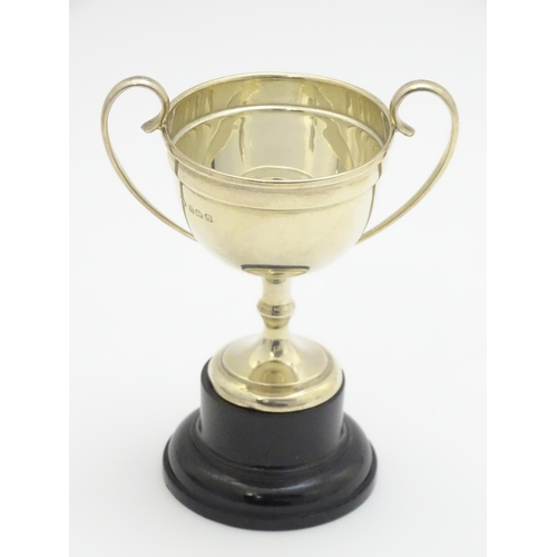 416 - A silver twin handled trophy cup, hallmarked Birmingham 1927, maker William Hutton & Sons Ltd. On an... 