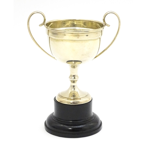 416 - A silver twin handled trophy cup, hallmarked Birmingham 1927, maker William Hutton & Sons Ltd. On an... 