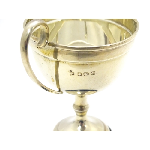 416 - A silver twin handled trophy cup, hallmarked Birmingham 1927, maker William Hutton & Sons Ltd. On an... 