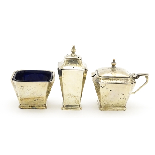 420 - An Art Deco three piece silver cruet set comprising salt, pepper and mustard pot with blue glass lin... 