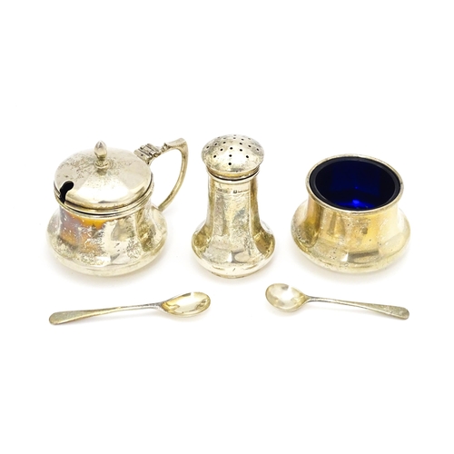 425 - A silver three piece cruet comprising pepper, salt and mustard with matching salt and mustard spoons... 