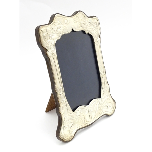 452 - An easel back photograph frame with silver surround with embossed Art Nouveau style decoration, hall... 