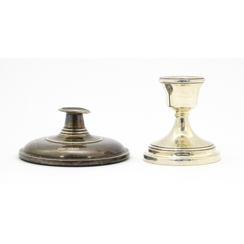 595 - A silver taperstick holder hallmarked Birmingham 1965. Together with a small silver candlestick hall... 