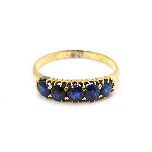 691 - A yellow gold ring set with 5 sapphires.  Ring size approx. J