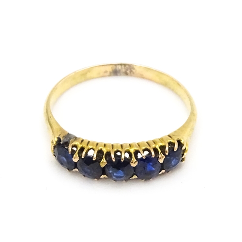 691 - A yellow gold ring set with 5 sapphires.  Ring size approx. J