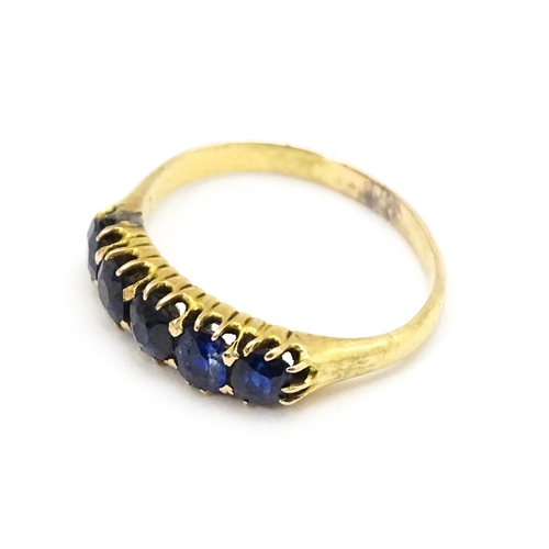 691 - A yellow gold ring set with 5 sapphires.  Ring size approx. J