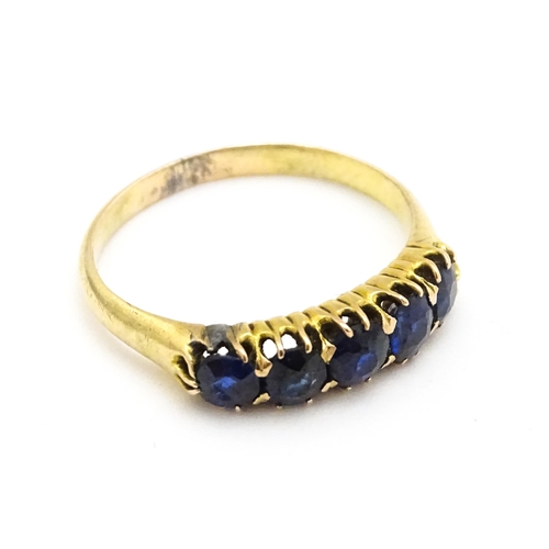 691 - A yellow gold ring set with 5 sapphires.  Ring size approx. J