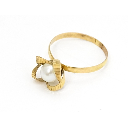 692 - A yellow gold ring set with central pearl Ring size approx. K