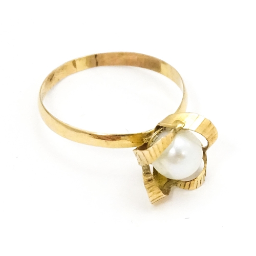 692 - A yellow gold ring set with central pearl Ring size approx. K