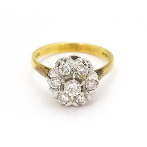 695 - An 18ct gold ring set with diamonds in a floral cluster setting. Ring size approx. L 1/2