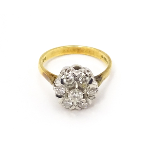 695 - An 18ct gold ring set with diamonds in a floral cluster setting. Ring size approx. L 1/2