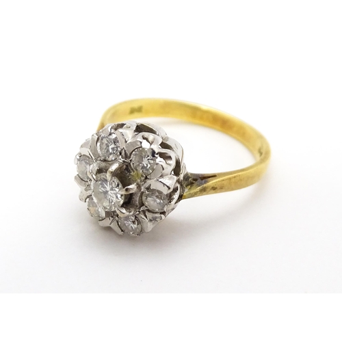 695 - An 18ct gold ring set with diamonds in a floral cluster setting. Ring size approx. L 1/2