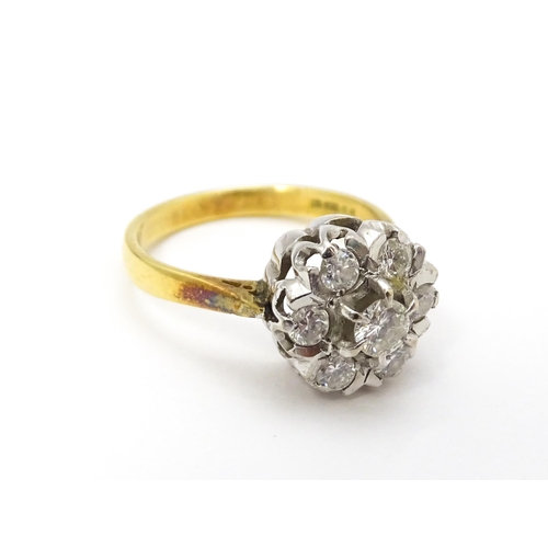 695 - An 18ct gold ring set with diamonds in a floral cluster setting. Ring size approx. L 1/2