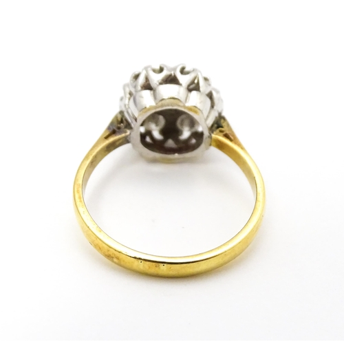 695 - An 18ct gold ring set with diamonds in a floral cluster setting. Ring size approx. L 1/2