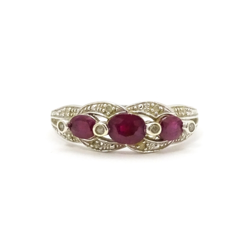 697A - A 9ct white gold ring set with rubies and diamond.  Ring size approx. M 1/2