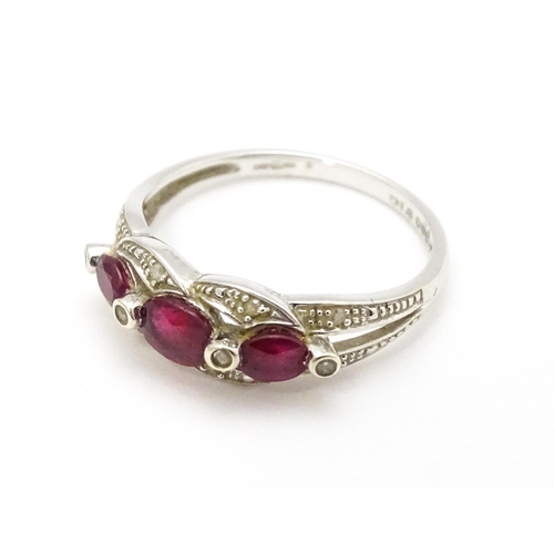 697A - A 9ct white gold ring set with rubies and diamond.  Ring size approx. M 1/2