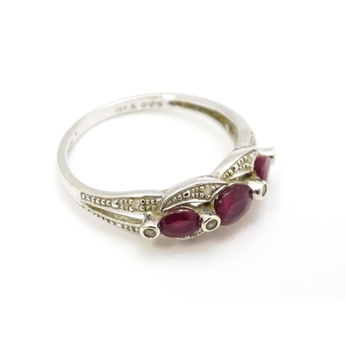 697A - A 9ct white gold ring set with rubies and diamond.  Ring size approx. M 1/2