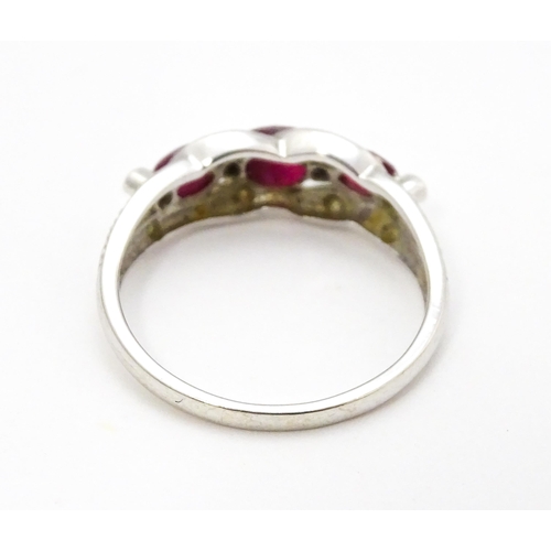 697A - A 9ct white gold ring set with rubies and diamond.  Ring size approx. M 1/2