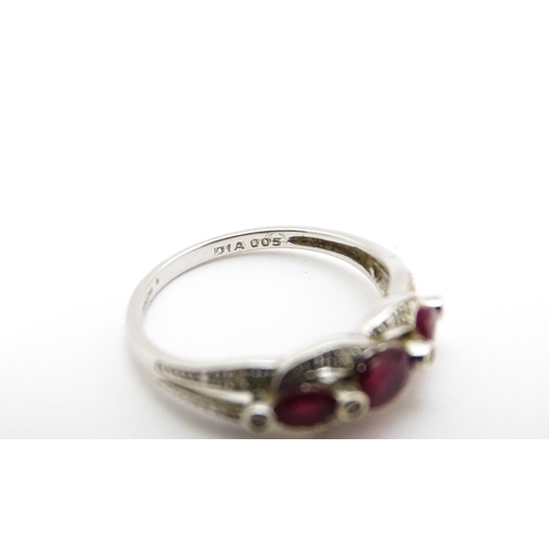 697A - A 9ct white gold ring set with rubies and diamond.  Ring size approx. M 1/2