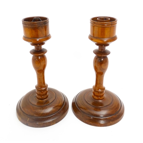 1100 - A pair of treen turned wooden candlesticks. Approx. 9 1/4