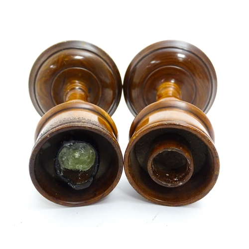 1100 - A pair of treen turned wooden candlesticks. Approx. 9 1/4