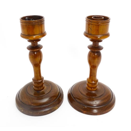 1100 - A pair of treen turned wooden candlesticks. Approx. 9 1/4