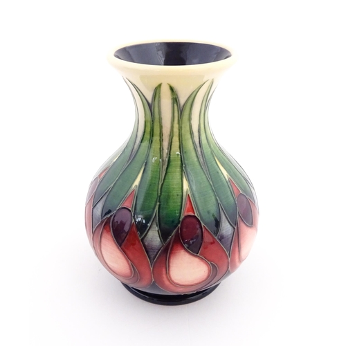 138 - A Moorcroft vase of squat form with a flared rim decorated in the April Tulip pattern designed by Em... 