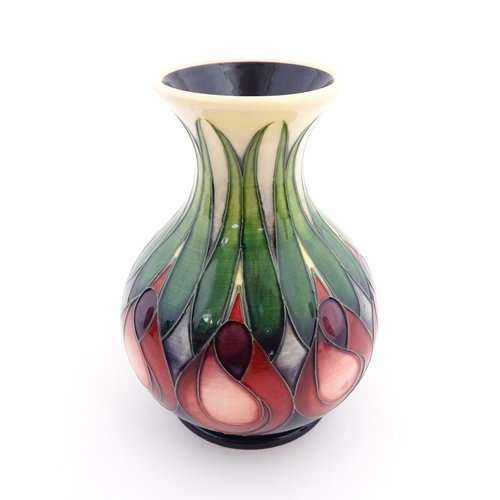 138 - A Moorcroft vase of squat form with a flared rim decorated in the April Tulip pattern designed by Em... 