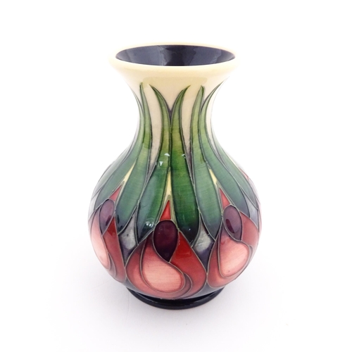 138 - A Moorcroft vase of squat form with a flared rim decorated in the April Tulip pattern designed by Em... 